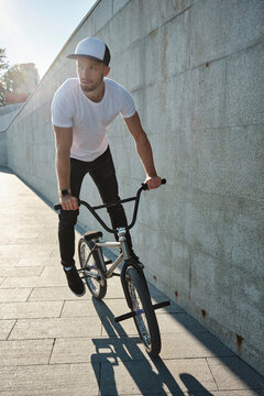 Man riding BMX bike near concrete wall