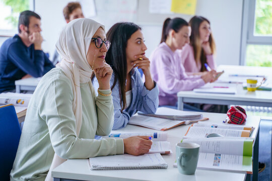 Multi-ethnic Students At Desk Studying Together In Classroom