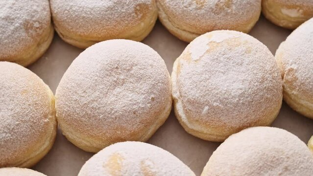 Berliner donut. Fresh Berliner doughnuts powdered with sugar powder in a cardboard box in a bakery, 4K video footage