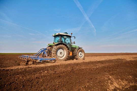 Tractor plowing field in early spring