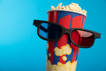 Movie clapper, pop corn, 3D glasses and film reel on blue background. Collage design