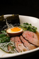 Traditional ramen noodle soup with brisket, spinach and egg