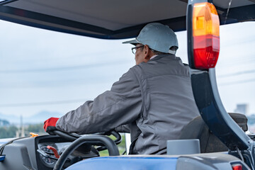 Naklejka premium トラクターを運転するシニア男性