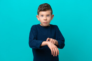 Little kid boy isolated on blue background making the gesture of being late