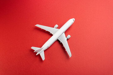 White plane on a red background. Airline operators, air carriers. Business and tourism. Travel. Logistics and transport infrastructure. World communication and commercial flights. - Powered by Adobe