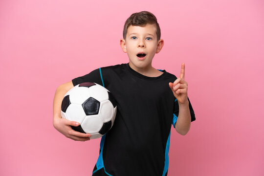 Little caucasian football player boy isolated on pink background thinking an idea pointing the finger up