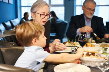 Grandparents and grandson sitting at a festive table
