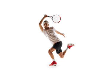 Dynamic image of concentrated young man, tennis player practicing, playing, hitting ball with...