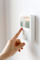 Home thermostat with digital panel for adjusting central heating or air conditioner