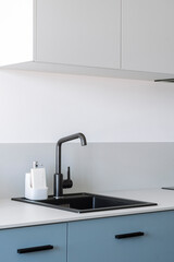Close up of ceramic sink with tap on grey counter top in kitchen