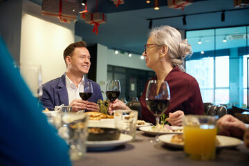 Happy man and aged woman in restaurant celebrating new year