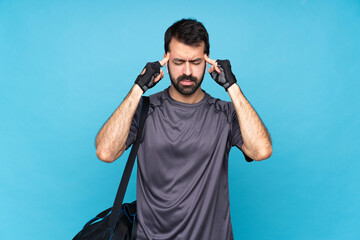 Young sport man with beard over isolated blue background with headache