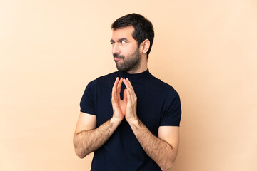 Caucasian handsome man over isolated background scheming something