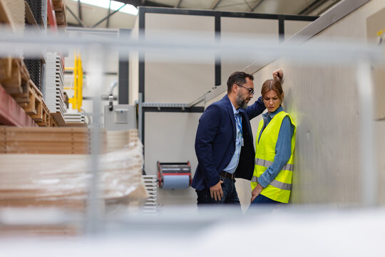 Female worker in manufactury feeling vulnerable and intimidated by superior manager, forced touching at workplace. Sexual harassment at work.