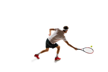 Dynamic image of concentrated young man, tennis player practicing, playing, hitting ball with racket isolated over white background. Concept of sport, hobby, active and healthy lifestyle, competition - Powered by Adobe