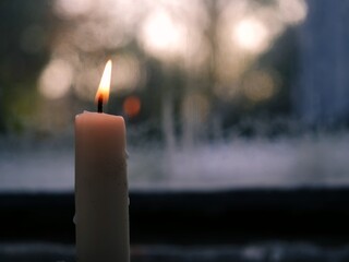 Candle flickers in cold winter window background