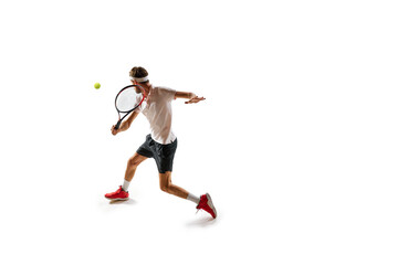Concentrated man, tennis athlete in motion during gamer, practicing, playing, hitting ball with racket isolated over white background. Sport, hobby, active and healthy lifestyle, competition concept