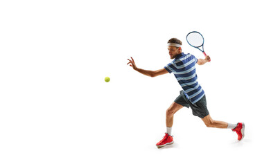Ambitious and concentrated man, tennis player in motion, practicing, hitting ball with racket, training isolated over white background. Concept of sport, hobby, active, healthy lifestyle, competition