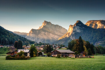 Peaceful village on hill with mountain range among French Alps at Sixt Fer a Cheval, France - obrazy, fototapety, plakaty