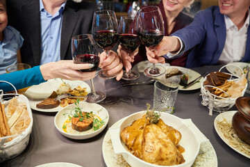 Unrecognizable humans hands holding clinking glasses at Christmas party