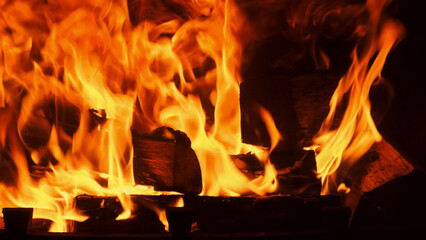 Burning log of firewood in fireplace. Texture of a blazing fire in the fireplace Close up abstract...