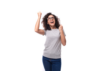 Obraz na płótnie Canvas happy european woman with black curly hair wears eyeglasses and dances on white background with copy space