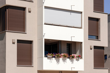 Window Blinds and Balcony Shutters of Modern Facade Multifamily Apartment Building. Brown External...