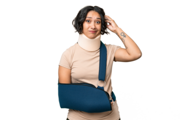 Young argentinian woman wearing neck brace and sling over isolated background having doubts