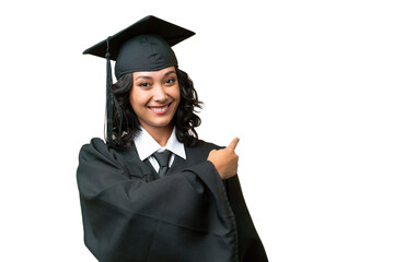 Young university graduate Argentinian woman over isolated background pointing back