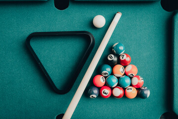 Sports game of billiards on a green cloth.Multi colored billiard balls in the form of a triangle...