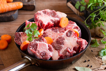 Oxtail Bones Being Browned in a frying pan on the table.