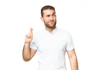 Young handsome blonde man over isolated chroma key background with fingers crossing and wishing the best
