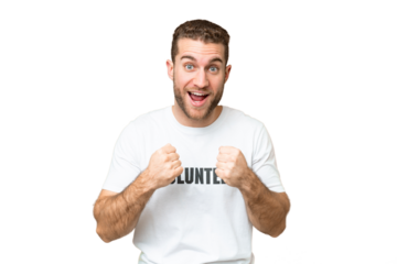 Young volunteer man over isolated chroma key background celebrating a victory in winner position