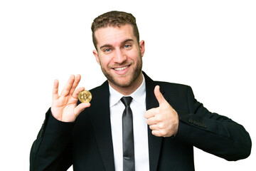 Young business blonde man holding a Bitcoin over isolated chroma key background giving a thumbs up gesture