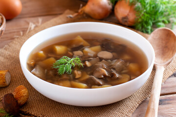 Mushroom soup in a white bowl on rustic table. Dinner concept.
