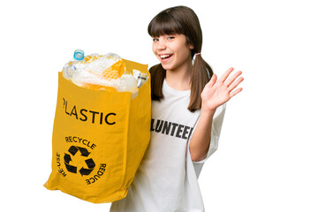 Little caucasian girl holding a bag full of plastic bottles to recycle over isolated background...