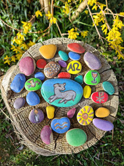 Bunt bemalte Steine mit christlichen Motiven. 