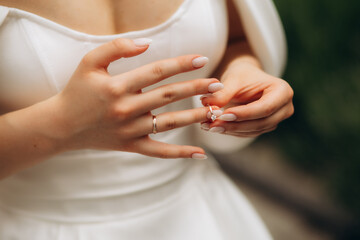 The bride is holding a gold ring in her hands, close-up. Morning of the bride. Wedding day....