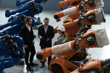 Group of businessmen discussing in the autonomous robotics warehouse storage. Industrial manufacturing by robotic arms concept - obrazy, fototapety, plakaty