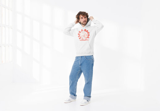 Mockup of man wearing customizable hoodie, putting hood up