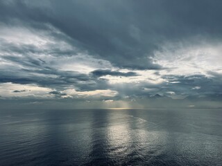 Fototapeta na wymiar Dark clouds reflection at the sea surface, evening sea horizon