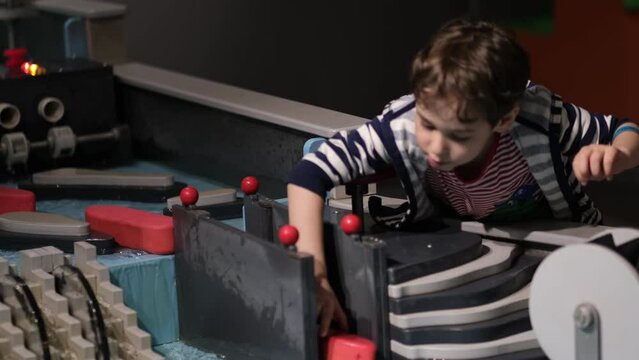 A young boy intently adjusts a water experiment, his curiosity in the laws of fluid dynamics evident. This moment captures the joy of interactive learning.
