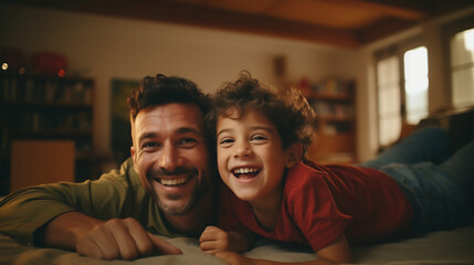Cheerful father and son having fun lying on floor and smiling, parents and children being friends - obrazy, fototapety, plakaty