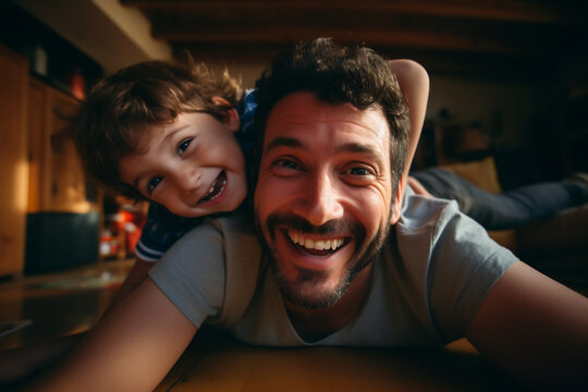 Cheerful father and son having fun lying on floor and smiling, parents and children being friends