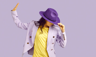Studio shot of stylish dancer girl. Beautiful young Caucasian woman in yellow top, lilac jacket and...