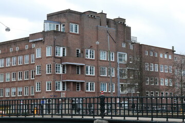 Naklejka premium Amsterdam Hoofdweg Street View with Bridge Railing and Brick Building, Netherlands