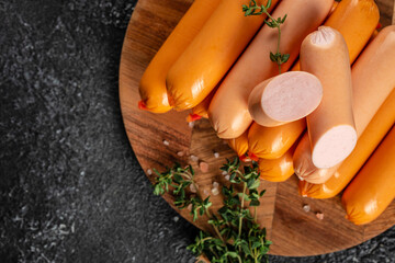 Boiled sausages on a wooden board, top view. copy space