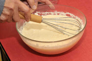 Préparation culinaire mélangée avec un fouet de cuisine dans un saladier en gros plan.