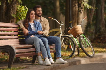 Fototapeta premium Beautiful couple spending time together in park, space for text