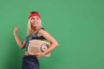 Happy hippie woman with retro radio receiver on green background. Space for text